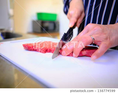 一位女廚師正在切割國產日本黑毛牛腿肉 一位女廚師正在切割國產日本黑毛牛腿肉 138774599
