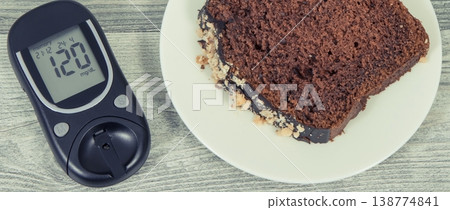 Glucose meter with high result sugar level and sweet chocolate cake. Nutrition during diabetes 138774841