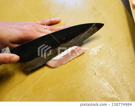 Cut the yellowtail fillet Cut the yellowtail fillet 138774984