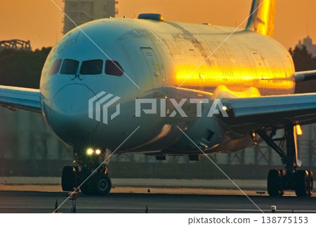 一架飛機沐浴在晨光中，準備起飛。 138775153