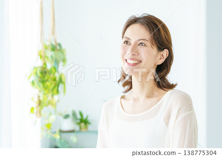 一位中年婦女站在窗邊的肖像。 一位中年婦女站在窗邊的肖像。 138775304