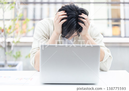 拿著在個人計算機前面的一個年輕人一個頭 138775593