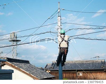 Electrical work on a utility pole in a residential area. Electrical work on a utility pole in a residential area. 138776415