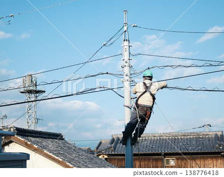 Electrical work on a utility pole in a residential area. Electrical work on a utility pole in a residential area. 138776418