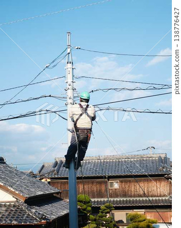 Electrical work on a utility pole in a residential area. Electrical work on a utility pole in a residential area. 138776427