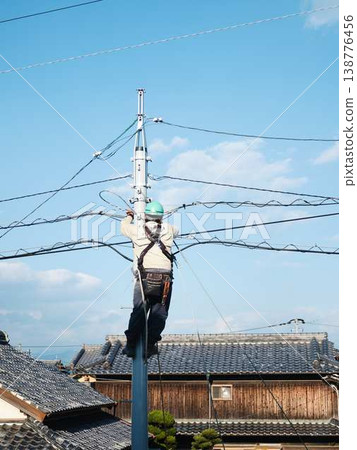 Electrical work on a utility pole in a residential area. Electrical work on a utility pole in a residential area. 138776456