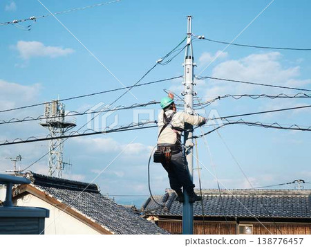 Electrical work on a utility pole in a residential area. Electrical work on a utility pole in a residential area. 138776457