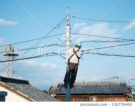 Electrical work on a utility pole in a residential area. Electrical work on a utility pole in a residential area. 138776460