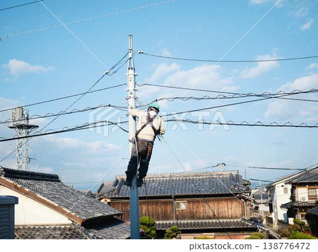在居民區電線桿上進行電氣作業。 在居民區電線桿上進行電氣作業。 138776472