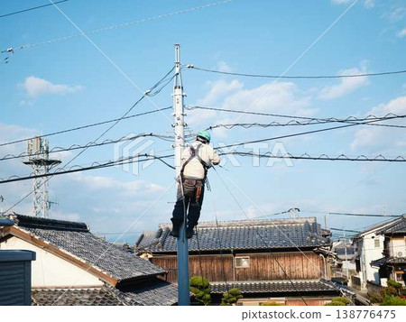 Electrical work on a utility pole in a residential area. Electrical work on a utility pole in a residential area. 138776475