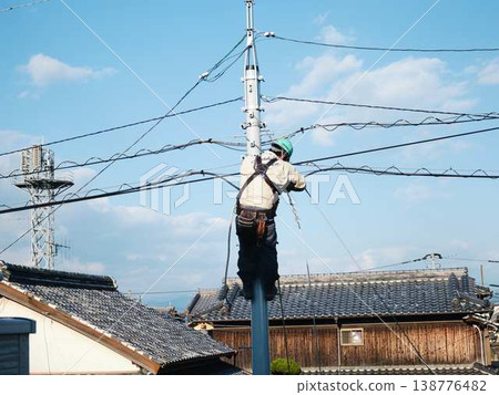 在居民區電線桿上進行電氣作業。 在居民區電線桿上進行電氣作業。 138776482