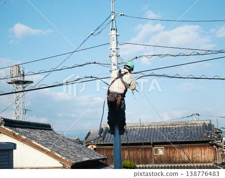 在居民區電線桿上進行電氣作業。 在居民區電線桿上進行電氣作業。 138776483