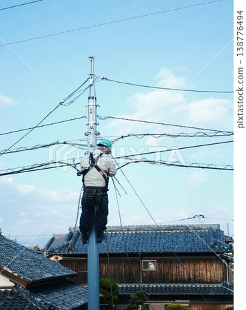 Electrical work on a utility pole in a residential area. Electrical work on a utility pole in a residential area. 138776494