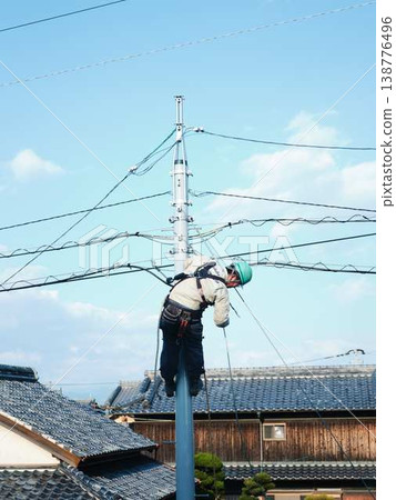 Electrical work on a utility pole in a residential area. Electrical work on a utility pole in a residential area. 138776496