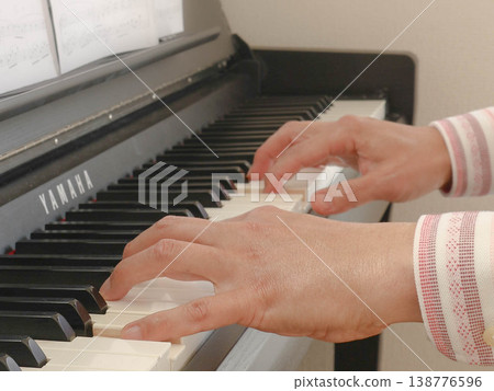 The hands and fingers of a man playing the piano. The hands and fingers of a man playing the piano. 138776596