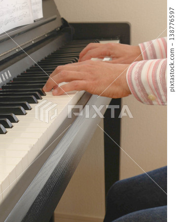 The hands and fingers of a man playing the piano. The hands and fingers of a man playing the piano. 138776597