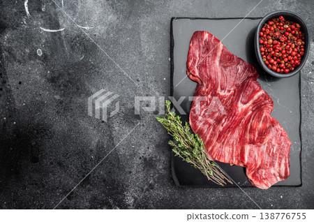 Raw beef steak cut with visible marbling and fibers on dark background with thyme and seasoning, fresh meat ingredient for grilling barbecue or cooking Raw beef steak cut with visible marbling and fibers on dark background with thyme and seasoning, fresh meat ingredient for grilling barbecue or cooking 138776755