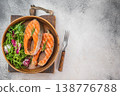 Grilled salmon steaks also known as red fish served in wooden bowl with fresh salad, light background with copy space 138776788