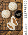 Asian steamed buns with meat filling cut open and served with dipping sauce, soft fluffy bao bread on wooden background 138776799