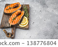 Cooked salmon steaks including sockeye with herbs citrus and seasoning on board, clean light background 138776804