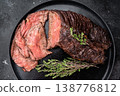 Sliced grilled beef hanger or onglet steak served on black plate with thyme and salt, dark stone background with copy space 138776812