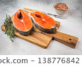 Raw chum salmon steaks with skin and bone on board with herbs and seasoning, clean background with copy space 138776842