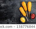 Crispy corndogs with ketchup and mustard on dark background, deep fried street food snack with copy space, top view 138776844