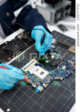 Computer Hardware Technician Repairing Motherboard with Soldering Iron in Electronics Lab. Computer Hardware Technician Repairing Motherboard with Soldering Iron in Electronics Lab. 138777712