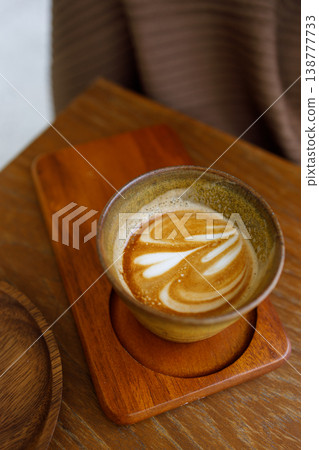 Cup of hot milk latte coffee on table by the window. Cup of hot milk latte coffee on table by the window. 138777733