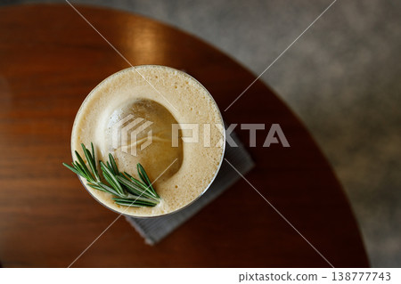 Cup of creation coffee Mocktail drink decorated with rosemary and foam on wooden table. Cup of creation coffee Mocktail drink decorated with rosemary and foam on wooden table. 138777743