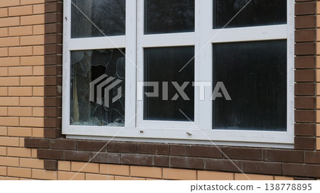 a broken window corner in an uninhabited new house with dusty glass and a dark, empty interior, as a symbol of a crime, theft, violence, or the destruction of an uninhabited cottage 138778895