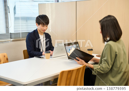 男女員工在會議室使用電腦工作或參加網路會議。 138779395
