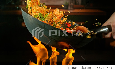 Freeze Motion of Flying Paella Meal with Vegetable and Prawns into Wok Pan Freeze Motion of Flying Paella Meal with Vegetable and Prawns into Wok Pan 138779684