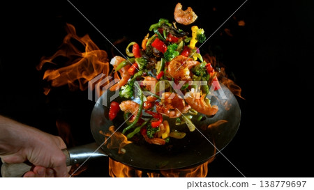 Freeze Motion of Flying Asian Meal with Vegetable and Prawns into Wok Pan Freeze Motion of Flying Asian Meal with Vegetable and Prawns into Wok Pan 138779697