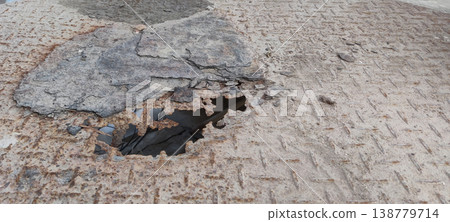 Corroded iron sheet with rust hole showing decay from moisture and environmental damage 138779714