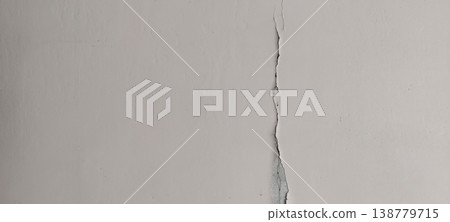 Cracked interior wall with long vertical split showing structural stress damage and aging surface condition Cracked interior wall with long vertical split showing structural stress damage and aging surface condition 138779715