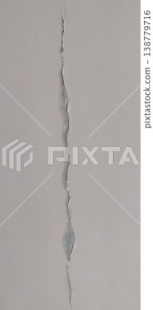 Cracked wall surface with visible vertical split showing structural damage and aging 138779716