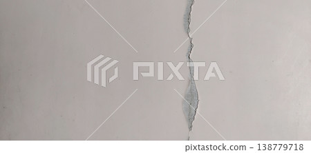 Damaged wall with deep crack line showing stress fracture and surface weakness 138779718