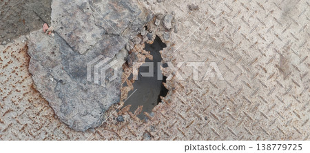 Rusty iron sheet with visible hole caused by water exposure and long term moisture corrosion damage 138779725