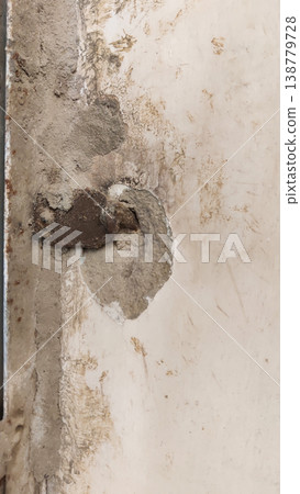 Rusted metal anchor embedded in cracked concrete wall 138779728