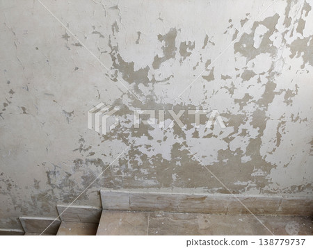 Staircase wall with peeling paint and damaged surface near steps indoors Staircase wall with peeling paint and damaged surface near steps indoors 138779737
