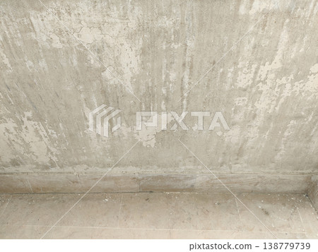 Wall base with completely peeled paint exposing rough surface near floor area 138779739
