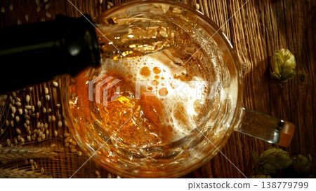 Pouring Beer into Pint Glass on Old Wooden Table, Top Down View. 138779799