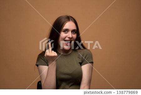 Young woman showing rude middle finger gesture with offensive expression, conveying disrespect and frustration Young woman showing rude middle finger gesture with offensive expression, conveying disrespect and frustration 138779869