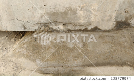 Damaged concrete wall with cracks and moisture stains 138779974