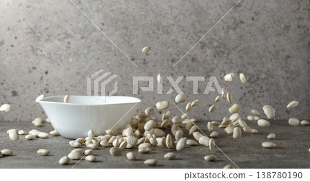 Dried white beans is poured in white ceramic bowl. Dried white beans is poured in white ceramic bowl. 138780190