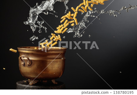 Vintage brass pot and pasta with a splash of water in motion. 138780195