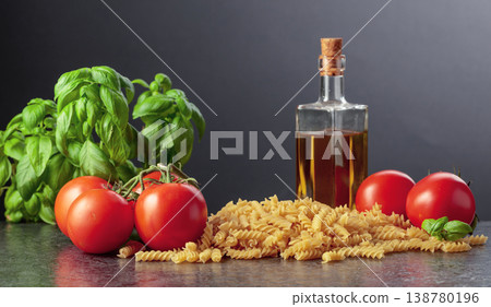 Fusilli pasta with olive oil, tomatoes and basil on a black background. Fusilli pasta with olive oil, tomatoes and basil on a black background. 138780196