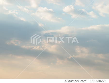 A breathless celestial canvas transitions from soft cerulean to a warm apricot glow. Wispy, cotton-like clouds drift through the upper reaches, their luminous edges softened by a gentle light. A breathless celestial canvas transitions from soft cerulean to a warm apricot glow. Wispy, cotton-like clouds drift through the upper reaches, their luminous edges softened by a gentle light. 138780225