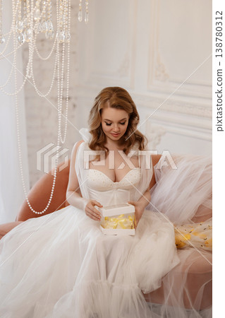 Bride Relaxes On Plush Pink Sofa. Soft Lighting Enhances Bridal Elegance And Quiet Joy Bride Relaxes On Plush Pink Sofa. Soft Lighting Enhances Bridal Elegance And Quiet Joy 138780312